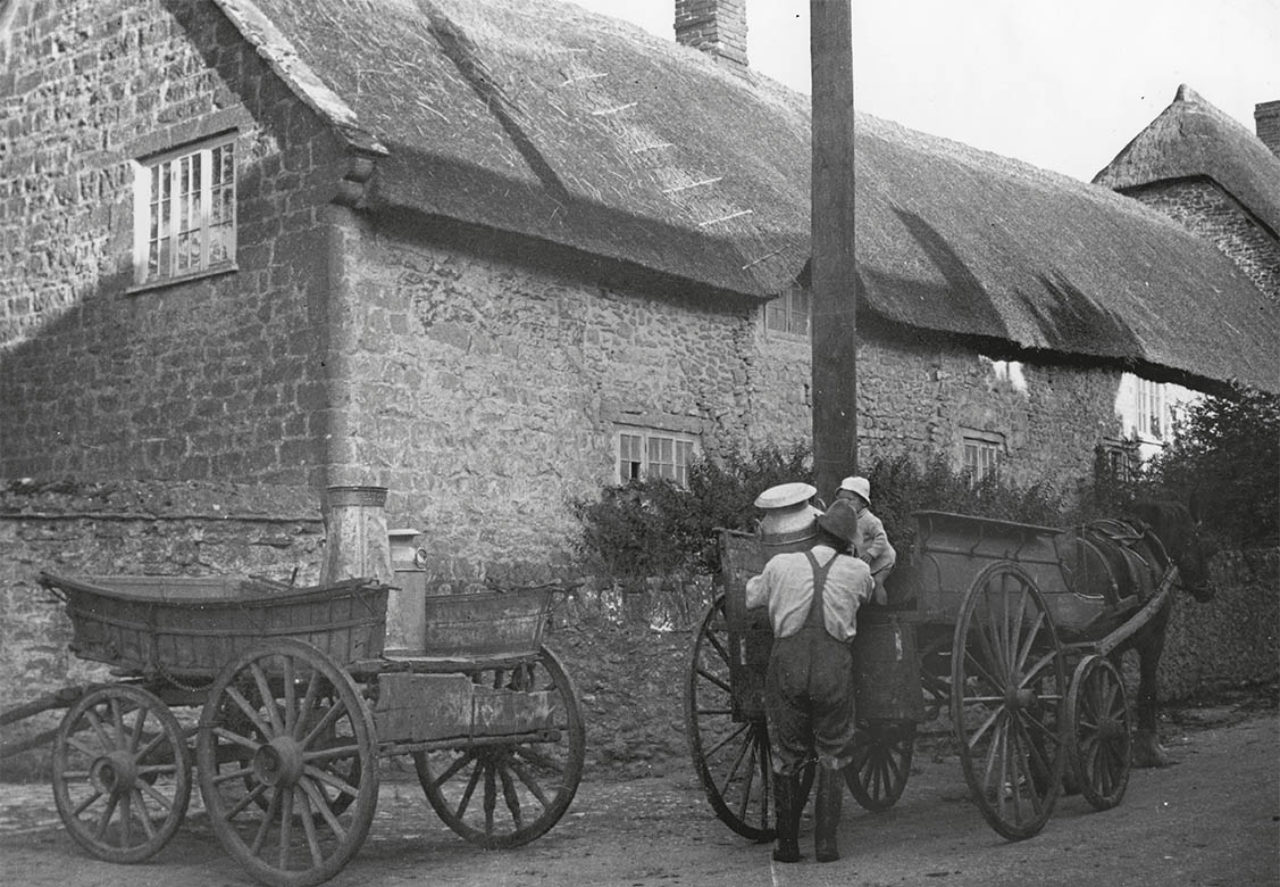 Fred Kerley transfers a milk churn from his cart to the Lenthall’s at Manor Farm, Burton Bradstock